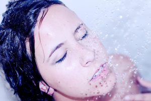 Adult woman shampooing hair and showering